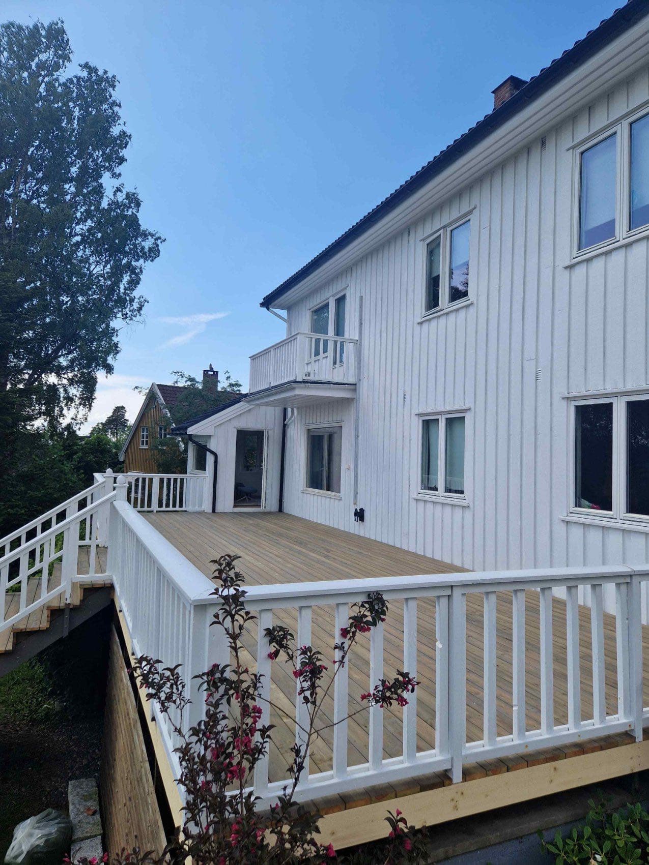 Nyoppusset terrasse med hvitt rekkverk på hvitmalt bolig, Moss-Jeløy